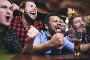 Men watching television and cheering for team